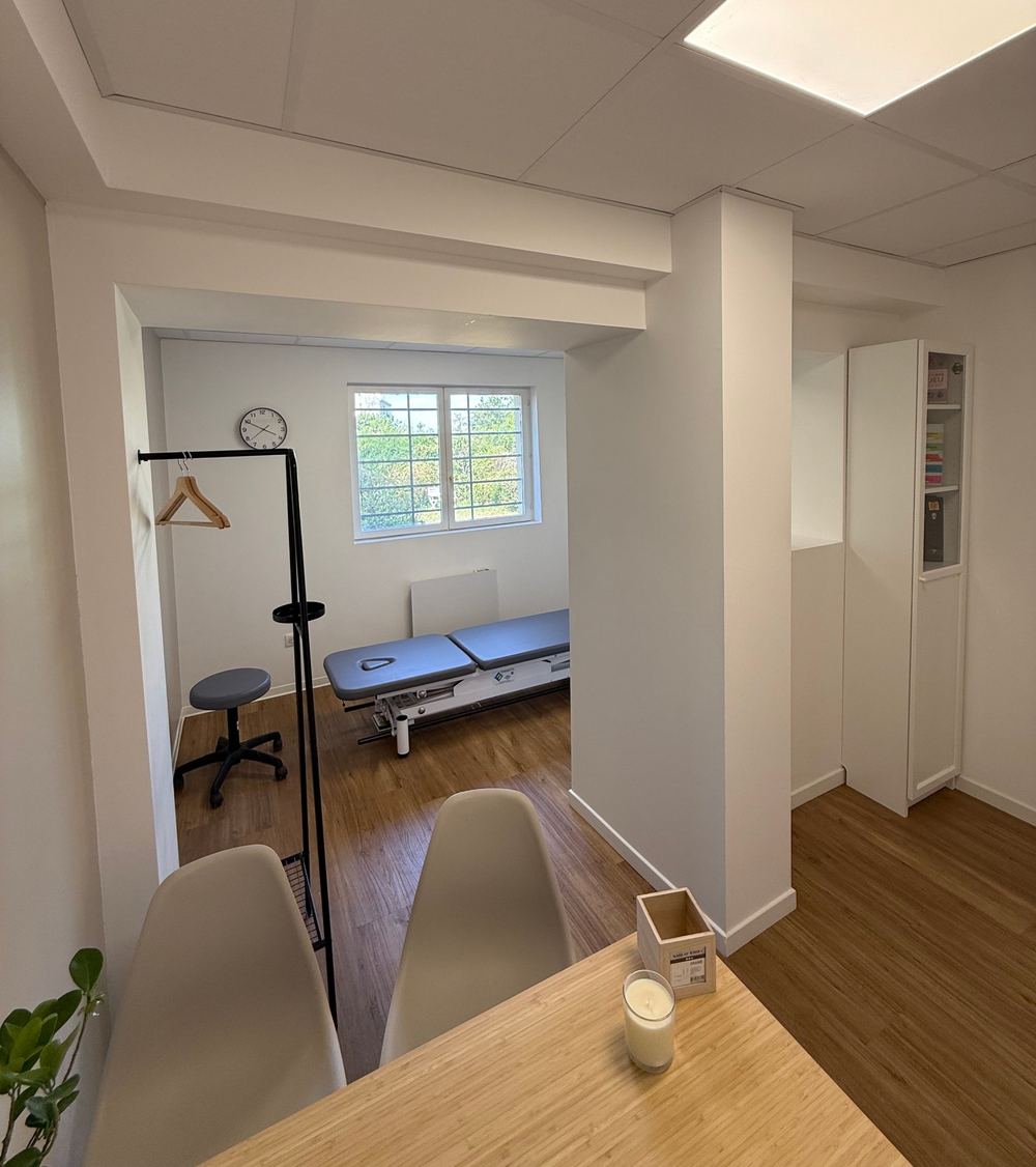 Salle de soin avec table d'ostéopathie et fenêtre sur la verdure
